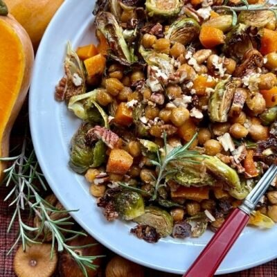 Maple-Balsamic Brussels and Chickpea Bake with Roasted Squash, Figs, and Pecans on a White Plate