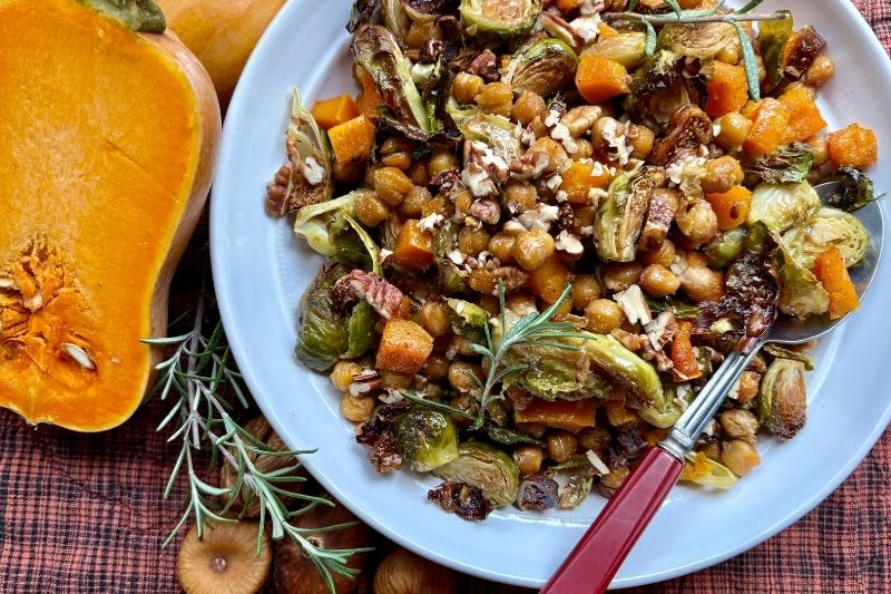 Maple-Balsamic Brussels and Chickpea Bake with Roasted Squash, Figs, and Pecans on a White Plate