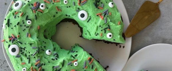 Monster Bundt Cake Monster Bundt Cake With Green Frosting, Candy Eyeballs and Halloween Sprinkles on White Plate
