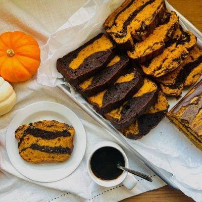Pumpkin-Chocolate Marble Loaf Cake Sliced on Baking Tray with Coffee and Mini Pumpkins