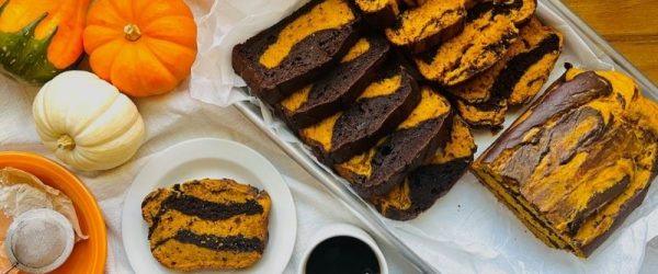 Pumpkin-Chocolate Marble Loaf Cake Sliced on Baking Tray with Coffee and Mini Pumpkins