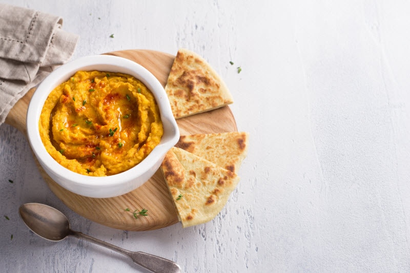 Spiced Pumpkin Hummus With Pita Bread on Wooden Cutting Board