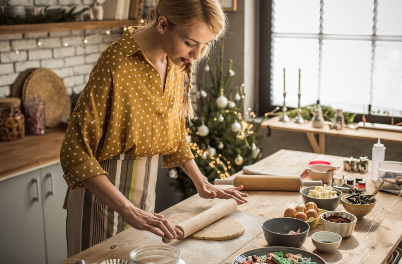 Woman Rolling Dough on Countertop to Make Cookies as She Enjoys Mindful Baking for the Holidays