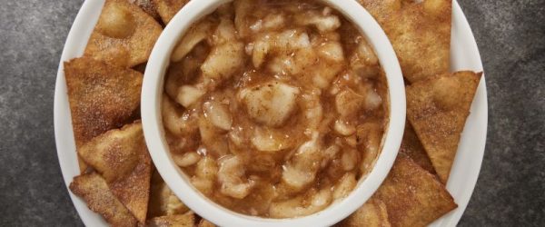 Cinnamon-Sprinkled Apple Salsa in a Round Bowl Set in the Middle of a Round Serving Plate Arrayed With Cinnamon Chips
