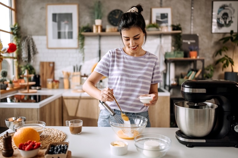 Best Sugar Substitutes for Baking A Woman Adds a Granular Sweetener to a Mixing Bowl, Representing the Best Sugar Substitutes for Baking.