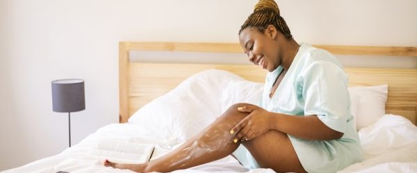 A Young Woman Applies Moisturizer to Her Legs, Representing Body Skincare.