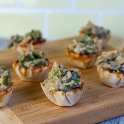 Green Bean Casserole Bites Sit on a Wooden Cutting Board.