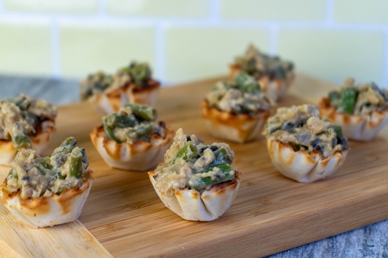 Green Bean Casserole Bites Sit on a Wooden Cutting Board.