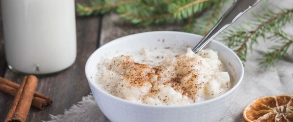 Tapioca Pudding Sprinkled with Cinnamon in a Dessert Bowl, Cinnamon Sticks are Strewn on The Wooden Table Top