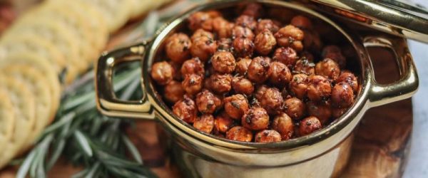 Roasted Rosemary-Infused Crispy Chickpeas _Resized Image_Toni Williams Roasted Rosemary-Infused Crispy Chickpeas in Metal Serving Pot on Charcuterie Board with Crackers, Veggies and Rosemary Sprigs