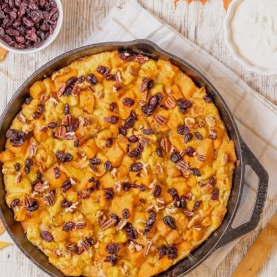 Sweet Potato Bread Pudding in Cast Iron Skillet, Topped with Cranberries and Pecans