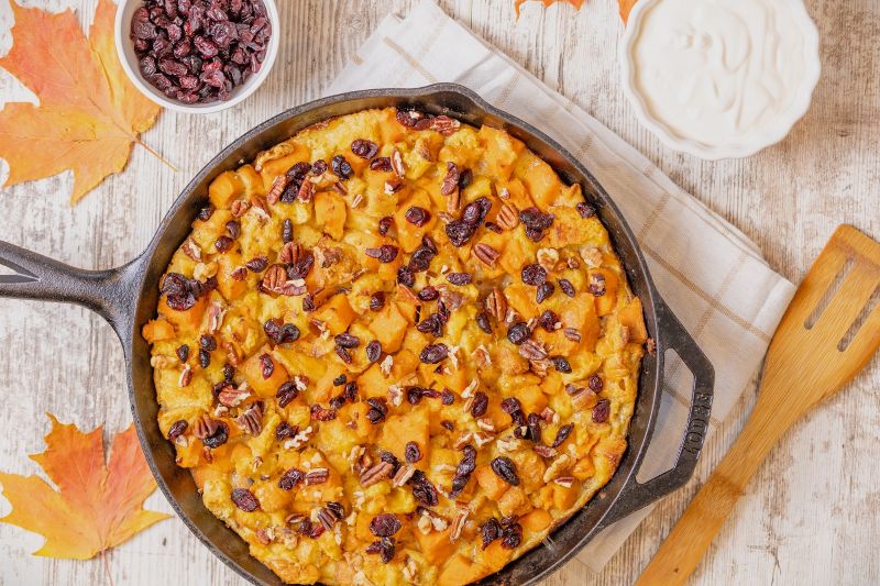 Sweet Potato Bread Pudding in Cast Iron Skillet, Topped with Cranberries and Pecans