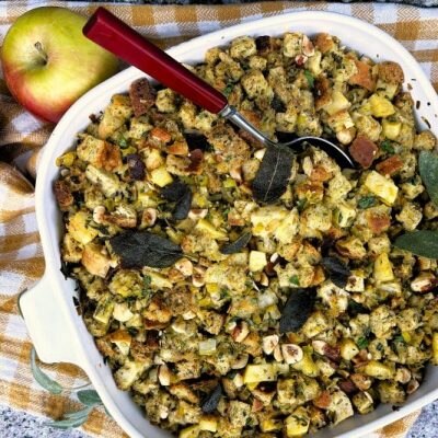 Sage Brown Butter & Apple Stuffing in Oven Pan on Granite Counter with Linen Kitchen Towel and Whole Apples