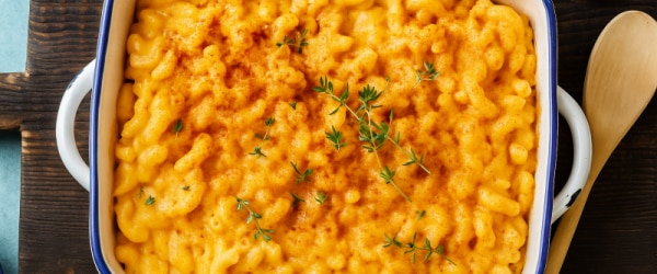 Sweet Potato Vegan Mac and Cheese in Blue and White Casserole Dish With Wooden Spoon and Checked Towel