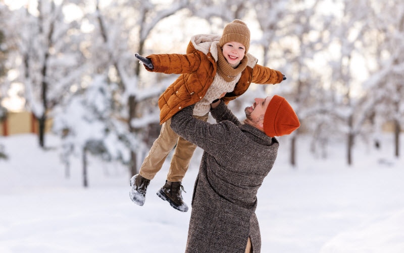 Kids’ Immune Support: 5 Gentle, Plant-Based Solutions Man Lifting Young Child in Airplane Pose in Snow to Represent Concept of Kids Immune Support Solutions