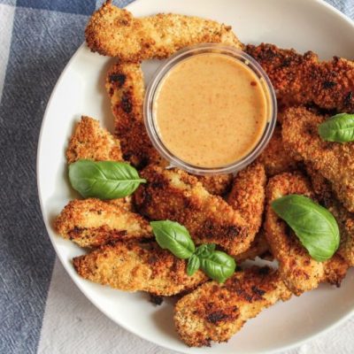 Golden-Brown Baked and Breaded Turkey Nuggets on a Serving Plate With a Dish of Dipping Sauce