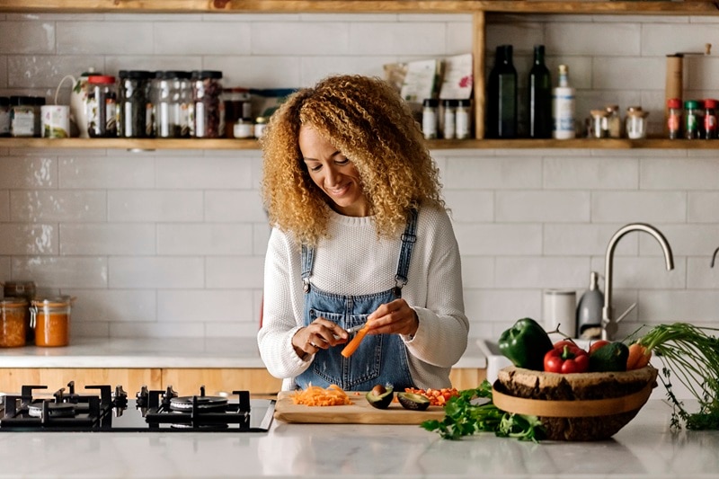 Food Anxiety A Woman Happily Prepares Food in a Beautiful Kitchen, Representing Someone Who Has Overcome Food Anxiety.