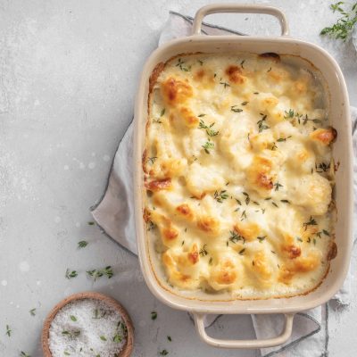 Cauliflower Gratin With Vegan Cheese on Counter in Baking Dish