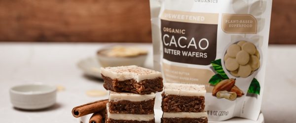 Gingerbread No Bake Cookie Dough Bars A Platter of Gingerbread No Bake Cookie Dough Bars Sits Beside a Package of Navitas Organics Cacao Butter Wafers.
