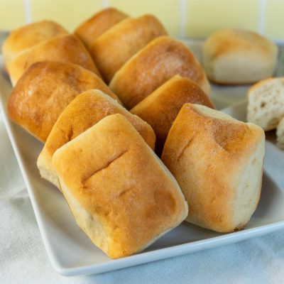 Vegan Sweet Dinner Rolls Made with Molasses on a Square Serving Platter Set on a Linen Napkin