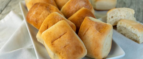 Vegan Sweet Dinner Rolls Made with Molasses on a Square Serving Platter Set on a Linen Napkin
