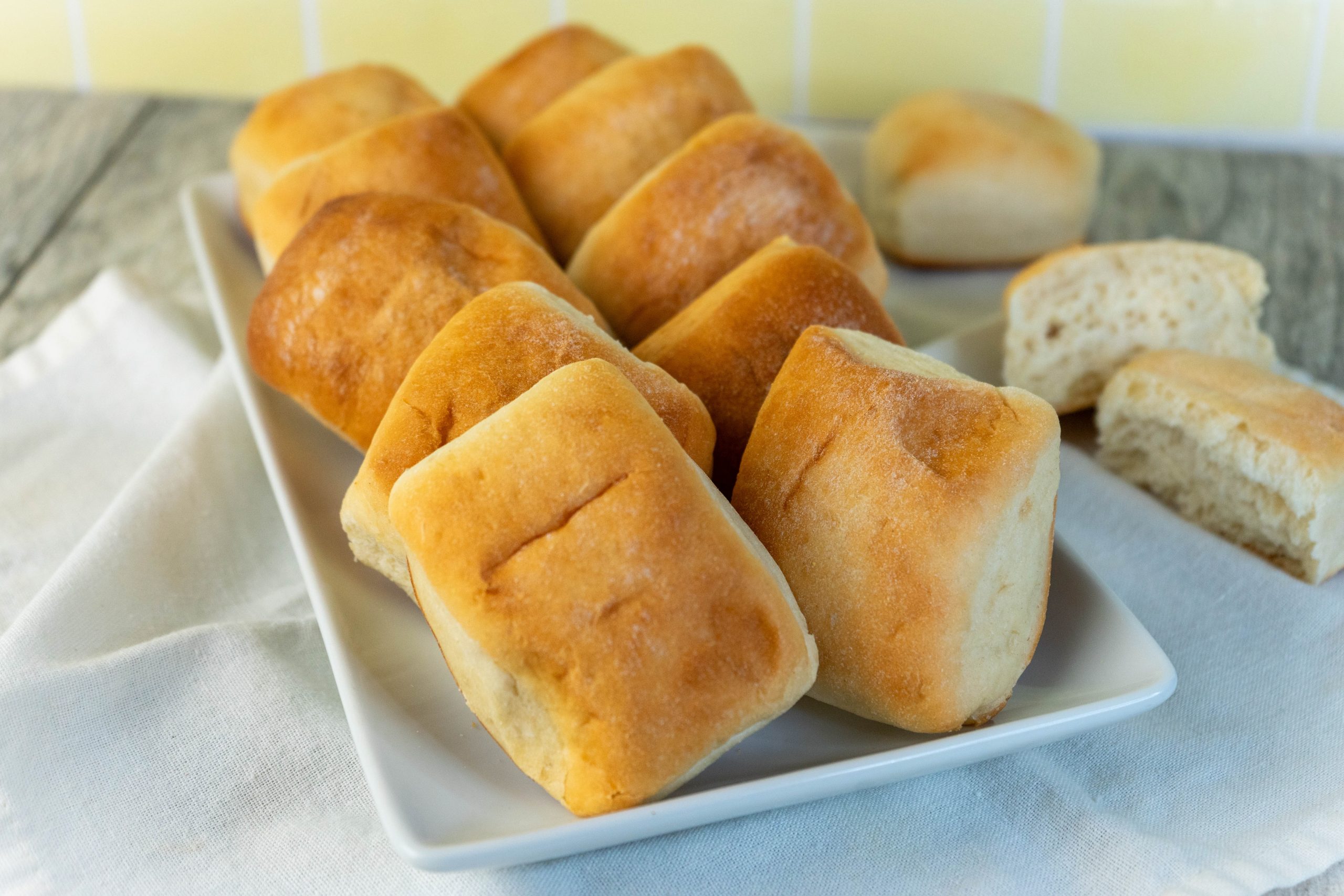 Vegan Sweet Dinner Rolls Made with Molasses on a Square Serving Platter Set on a Linen Napkin