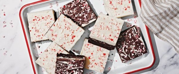 Brownies Topped with Swirled Chocolate Bark Dotted with Crushed Peppermint Candies in White Enamel Pan with Red Rim