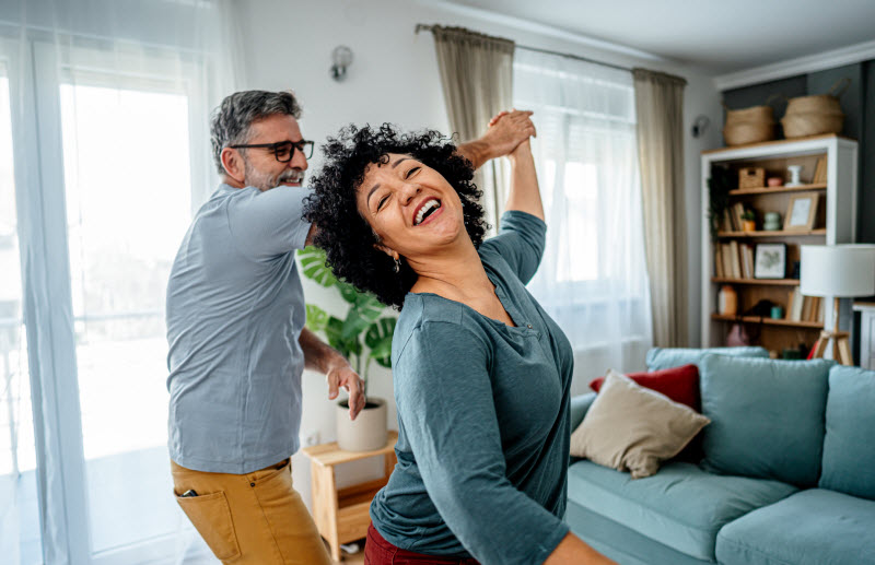 Concept of Testosterone Therapy for Women Represented by Happy Couple Dancing in Living Room