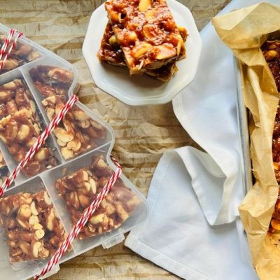 An Array of Homemade Peanut Brittle in a Christmas Tree-Shaped Gifting Box, on a Plate and in the Baking Pan