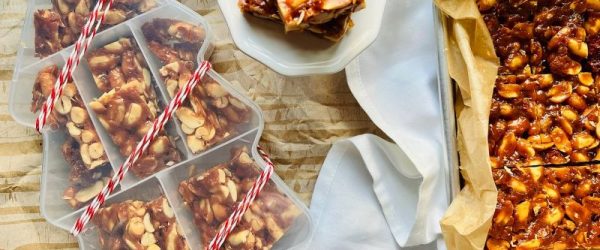 An Array of Homemade Peanut Brittle in a Christmas Tree-Shaped Gifting Box, on a Plate and in the Baking Pan