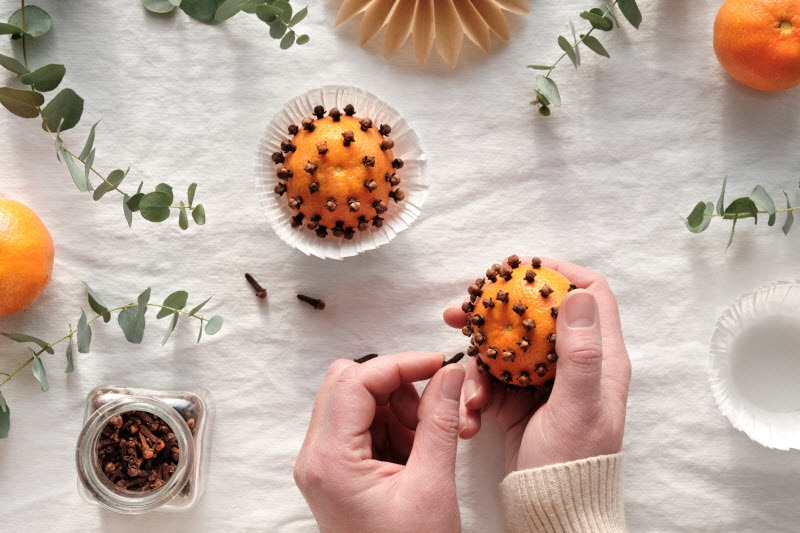 Vintage Holiday Craft - DIY Orange-Clove Pomander Balls Overhead View of Woman Making Holiday Orange and Cloves Pomanders