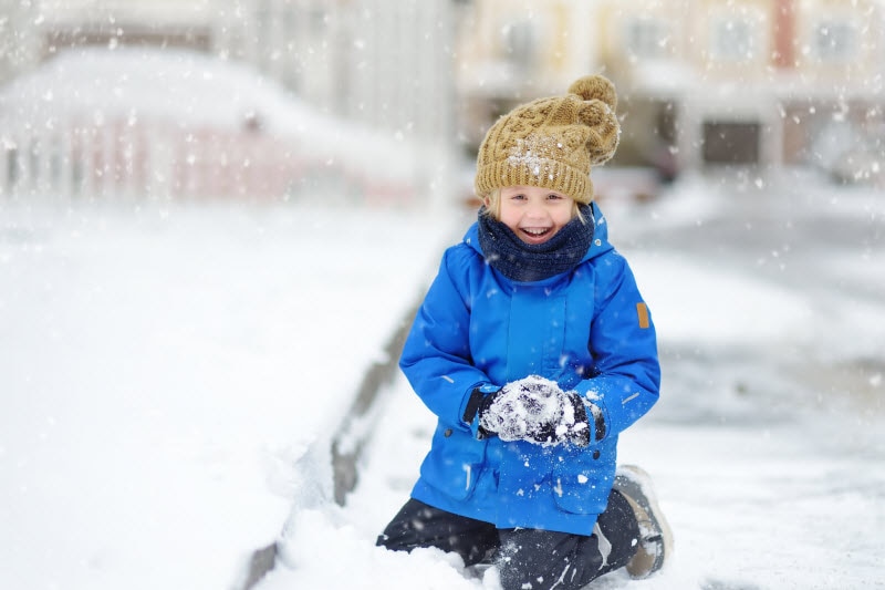 Concept of Winter Crafts for Kids Represented by Child in Blue Coat Playing Outside in Snow
