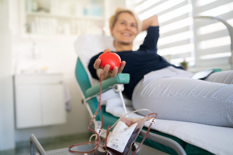 Smiling Woman on Medical Cart to Represent Concept of the Benefits of Donating Blood 