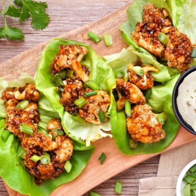 Golden Honey-Garlic Cauliflower Lettuce Wraps on Wooden Serving Board