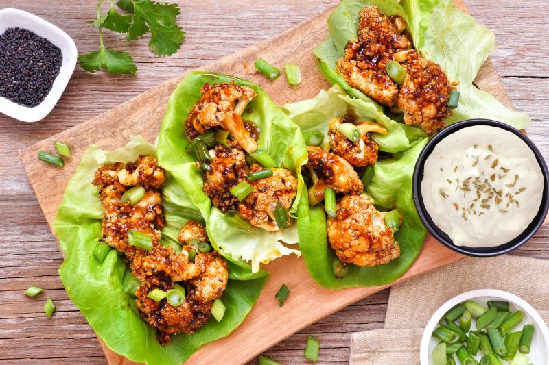 Golden Honey-Garlic Cauliflower Lettuce Wraps on Wooden Serving Board