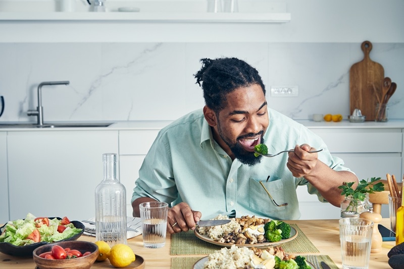 A Man Enjoys A Full Plate of Home-Cooked Food, Representing Healthy Comfort Food.