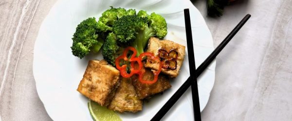 Baked Lemongrass Tofu Cubes on a Plate with Broccoli, Lime and Sliced Red Chili Pepper