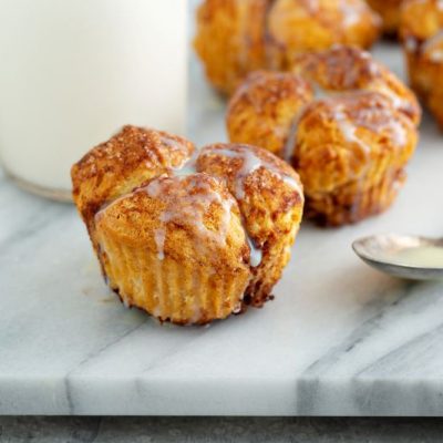 Monkey Bread Muffins Drizzled with Sugary Glaze on Marble Serving Board