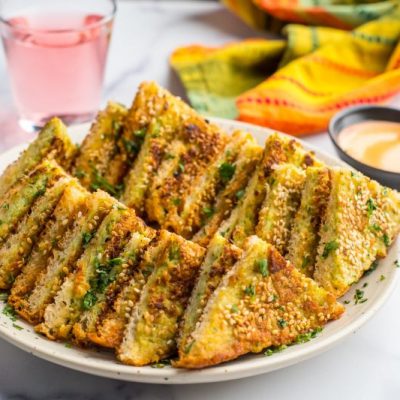 Shrimp Toast Recipe Shown on Serving Plate with a Bowl of Sauce Nearby