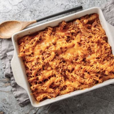 Sloppy Joe Casserole with Gooey Cheese in a Ceramic Baking Pan on a Marble Countertop