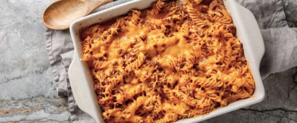 Sloppy Joe Casserole_Resized Image_Pam Higgins Sloppy Joe Casserole with Gooey Cheese in a Ceramic Baking Pan on a Marble Countertop