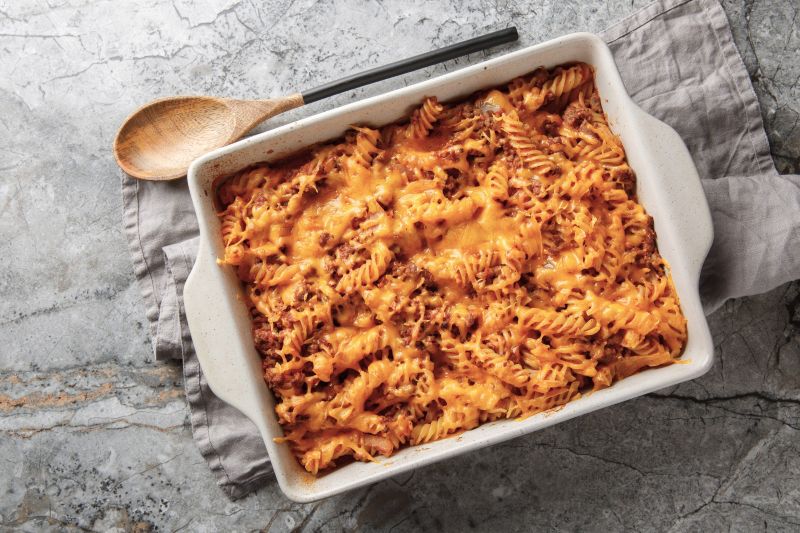 Sloppy Joe Casserole with Gooey Cheese in a Ceramic Baking Pan on a Marble Countertop