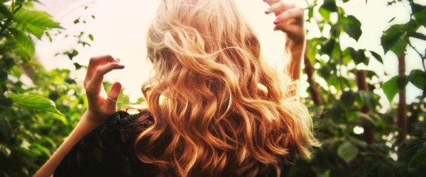 Back View of Woman With Gorgeous Wavy Blond Hair to Represent Concept of Hair Care Trends