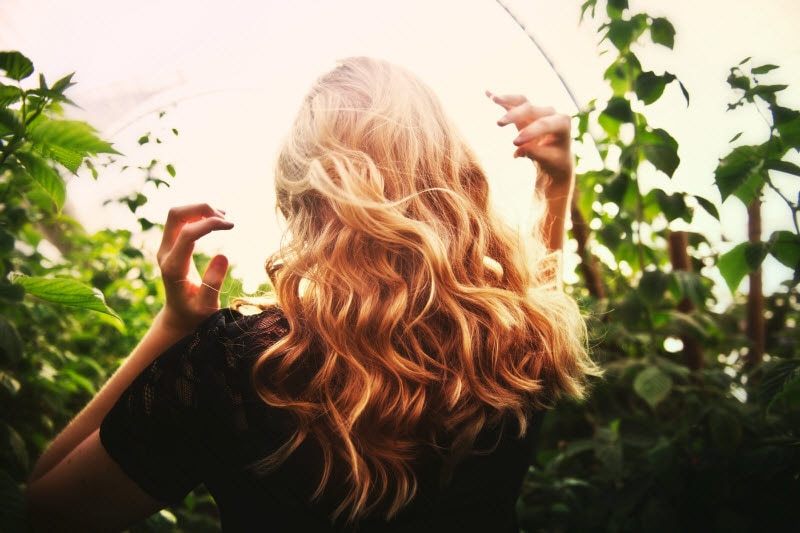 Back View of Woman With Gorgeous Wavy Blond Hair to Represent Concept of Hair Care Trends