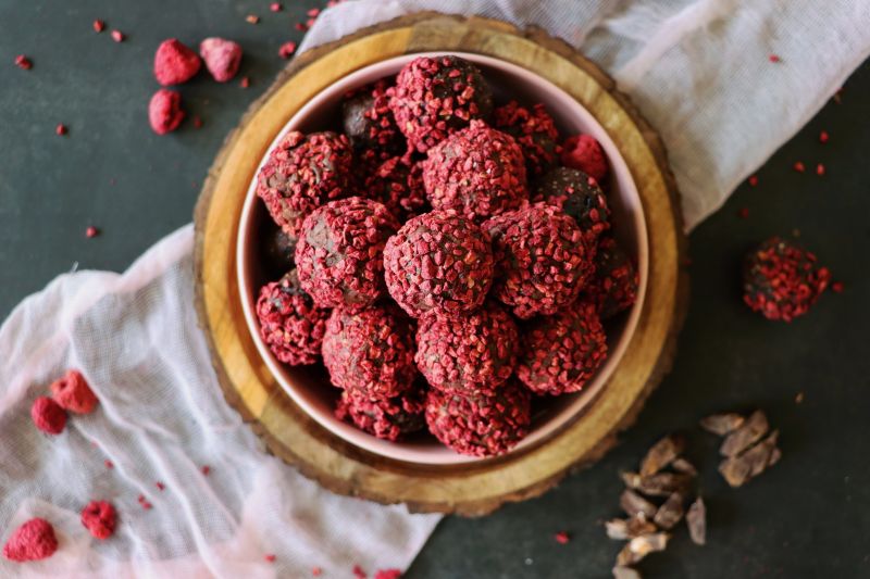 Vegan Raspberry-Covered Chocolate Truffles on a Wooden Bowl