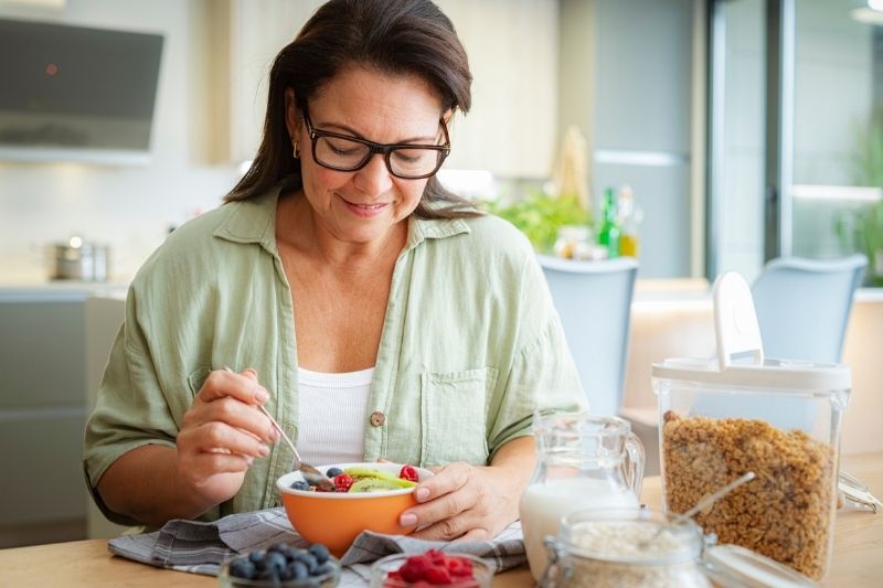 Woman Eating Breakfast Dealing With Insulin and Weight Gain