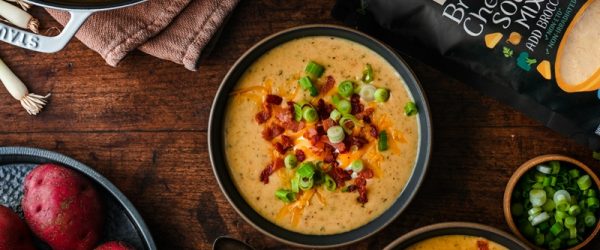 Two Bowls of Quick and Easy Potato Soup Are Topped With Bacon, Green Onions and Shredded Cheddar.