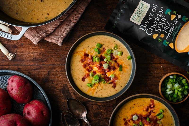 Two Bowls of Quick and Easy Potato Soup Are Topped With Bacon, Green Onions and Shredded Cheddar.